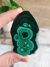 Load image into Gallery viewer, Malachite, with its striking green bands, is a powerful stone of protection and spiritual growth. It absorbs negativity and enhances your psychic abilities, making it an essential tool for manifesting your deepest desires
