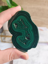 Load image into Gallery viewer, Embrace the transformative energy of Malachite. This protective crystal shields you from negativity while promoting spiritual growth. Its unique banded patterns reflect the layers of strength and clarity it brings to your life
